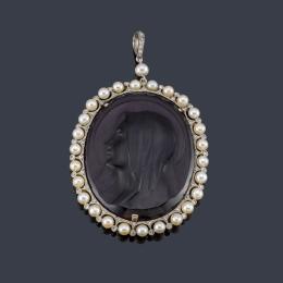 Lote 2088: GHISO
Medalla 'Belle Époque' con imagen de La Virgen realizado en cristal púrpura con orla de perlitas intercaladas con brillantes talla rosa. C. 1910.