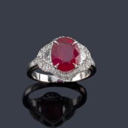 Lote 2140: Anillo con rubí talla oval de aprox. 3,50 ct con dos diamantes talla fantasía y orla de brillantes de aprox. 0,78 ct en total.