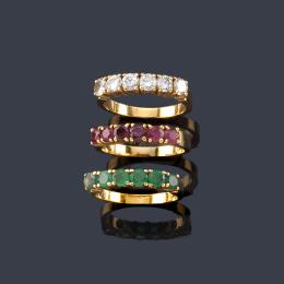 Lote 2149: Tres anillos con banda de brillantes, esmeraldas y rubíes en montura de oro amarillo de 18K.