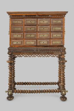 Lote 1221: Contador en madera de palosanto tallada y torneada, con decoración de "torcidos y tremidos", con cajones con escudos de cerradura en bronce recortado.
Portugal, S. XIX
