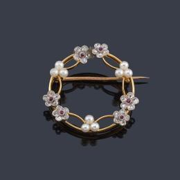 2071   -  Lote 2071: Broche circular con diseño de guirnalda floral con diamantes y perlitas, en montura de oro amarillo de 18K.