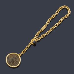 Lote 2563
LUIS GIL
Llavero con moneda antigua realizado en oro amarillo de 18K y remate de zafiro en cabujón.