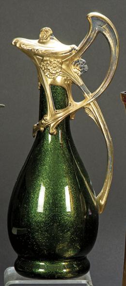 Lote 1260: Riedel Crystal, Kufstein, Austria h. 1900
Jarra con tapa Jugendstil de cristal y metal dorado con inclusión de aventurina verde.