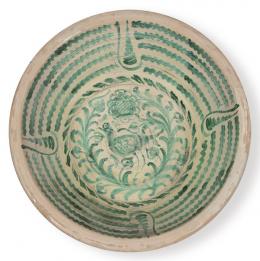 Lote 1494: Lebrillo en cerámica esmaltada verde de fajalauza con pájaro de pico entre vegetación en el asiento y arquillos en el alero. 
Granada, S. XIX