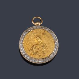 Lote 2100: Medalla devocional con La Imagen de La Virgen con El Niño en brazos cincelado sobre oro amarillo de 18K.