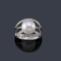 Lote 2379: YANES
Anillo con perla central de aprox. 10,28 mm sobre cuatro bandas de diamantes talla brillante.