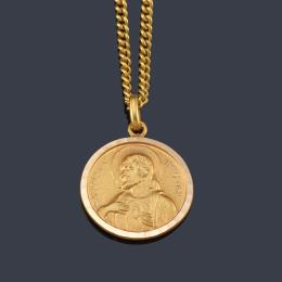 Lote 2435: Medalla devocional con La Imagen de La Virgen con el Niño en brazos y en el reverso El Sagrado Corazón en oro amarillo de 18K.