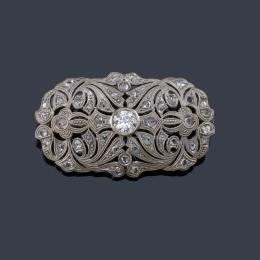 Lote 2511: Broche ovalado con diamantes talla antigua y rosa sobre motivos calados, en montura de oro blanco de 18K.