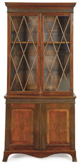 Lote 1091: Bookcase Jorge III en madera de caoba con dos puertas superiores vidriadas en astrágalo formando rombos, rematadas por cornisa con mútulo, gotas y arcos. Inglaterra, principios S. XIX