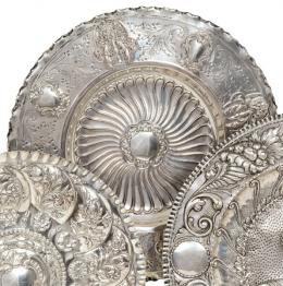 Lote 1247: Bandeja circular de plata española sin punzonar con decoración grabada y cincelada de hojss y cartelas
