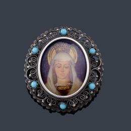 Lote 2010: Broche con Imagen de La Virgen Coronada pintada a mano, en montura de plata, con decoración de turquesas en el marco.