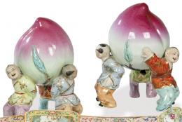 Lote 1462: Pareja de melocotones sostenidos por niños en porcelana china S. XX