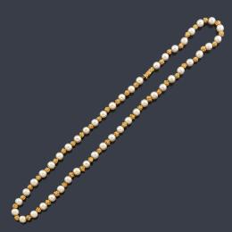 Lote 2118: YANES
Collar largo con perlas intercalado con motivos en oro amarillo de 18K.