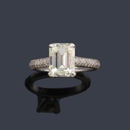 Lote 2238: Solitario con diamante talla esmeralda de aprox. 3,00 ct con brillantes en ambos brazos de aprox. 1,00 ct en total.
