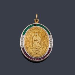 Lote 2303: Medalla devocional de La Virgen de Guadalupe con orla de brillantes, esmeraldas (falta una) y rubíes calibrados.