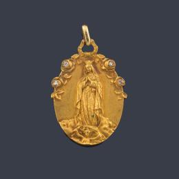 Lote 2481: Medalla devocional con la Imagen de La Virgen de Guadalupe delicadamente cincelada en oro amarillo de 18K.