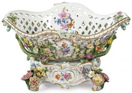Lote 1068: Centro de mesa en forma de cesta calada con flores adosadas sobre base estilo rococó en porcelana pintada y esmaltada de Meissen. Con marcas de fábrica y artista. Alemania, h. 1790