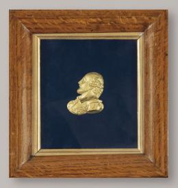 Lote 1110
"Retrato de Caballero de Perfil" de bronce dorado, cincelado, S. XIX. 
Con marco de madera clara.