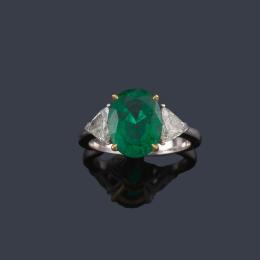 Lote 2340: Anillo con esmeralda (Zambia) talla oval de aprox. 3,36 ct con dos diamantes talla triángulo de aprox. 0,75 ct en total. Certificado Bellerophon Gemlab.