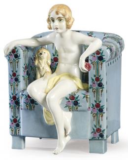 Lote 1041: Figura en porcelana de Goldscheider representando una niña con perro sentada en un sillón. Con sello en la base
Austria, hacia 1930.