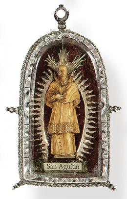 Lote 1174: Relicario de plata con imágen de San Agustín tallada en hueso S. XVIII al reverso imágen de Santa Bárbara pintada con reliquias de la Santa