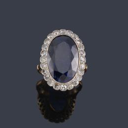Lote 2046: Anillo con zafiro talla oval de aprox. 14,85 ct con orla de diamantes talla 8/8.