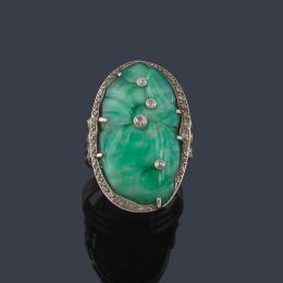 Lote 2052: Anillo con pieza de jade tallada salpicado de brillantes en montura de platino.