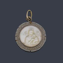 Lote 2056: Medalla devocional con La Imagen de La Virgen con El Niño realizado en nácar con orla de diamantes y perlitas. Ppios S. XX.