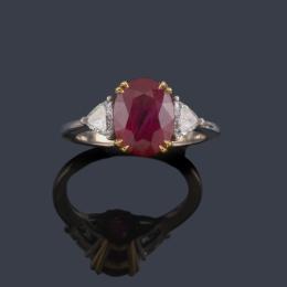 Lote 2349: Anillo con rubí talla oval de aprox. 4,01 ct con dos diamantes talla triángulo de aprox. 0,40 ct en total. Certificado C. Dunaigre Switzerland.