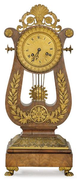 Lote 1008: Reloj de sobremesa imperio en madera de caoba y bronce dorado. Sobre un basamento cuadrado, se sitúa la caja del reloj en forma de lira que aloja la esfera del reloj. Francia, primer tercio S. XIX