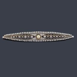 Lote 2033: Broche barrita con perla central de aprox. 6,88 mm y diamantes talla antigua, con orla de perlitas en montura de platino. Ppios S. XX.