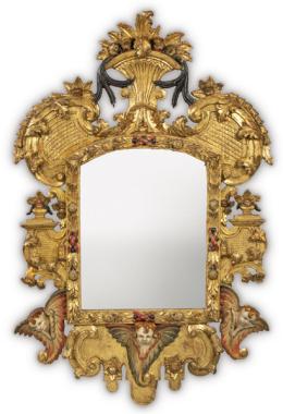 Lote 1046: Marco de espejo de estilo barroco, con perfil irregular en madera tallada y dorada con decoración de hojas de acanto flores y cabezas de angelitos policromados.
Finales S. XIX.