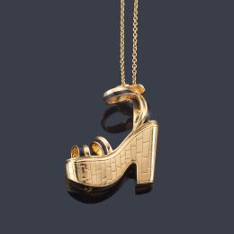 Lote 2326
FERRAGAMO'S
Colgante en forma de sandalia de tacón con detalles en esmalte negro, en montura de oro amarillo de 18K.