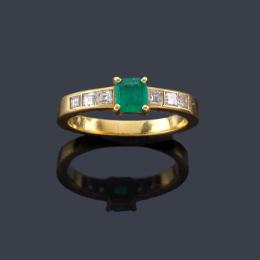 Lote 2330: Anillo con esmeralda central y banda de diamantes talla carré en ambos lados.
