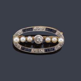 Lote 2042: Broche ovalado con banda central de perlitas y diamante talla antigua, con orla de zafiros calibrados. Ppios S. XX.