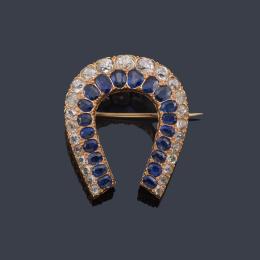 Lote 2057: Broche en forma de herradura con zafiros talla oval y diamantes talla de aprox. 4,90 ct en total. S. XIX.