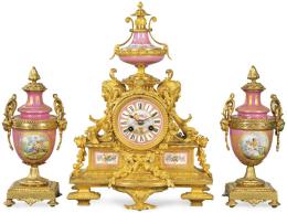 Lote 1048
Guarnición formada por reloj de sobremesa y dos copas Napoleón III, estilo Luis XVI en bronce y porcelana