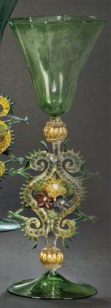 Lote 1096
Copa de cristal de Murano verde claro con depósito poligonal y vástago con eses adosadas, crestería y flores.