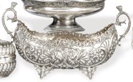 Lote 1137: Centro de mesa abarquillado de plata punzonada 900 SC
Con decoración repujada y cincelada de cartelas y flores