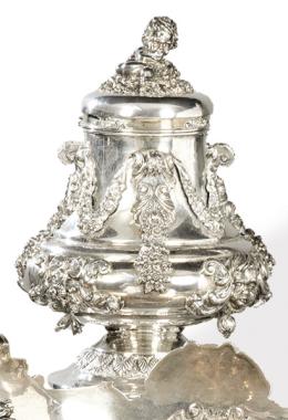 Lote 1202: Purera de plata española punzonada 1ª Ley de Silver Gena. 
Co decoración de amorcillos y guirnaldas florales colgantes en relieve.
