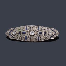 Lote 2063: Broche-placa oval con tres diamantes talla antigua y zafiros calibrados sobre diseño calado.