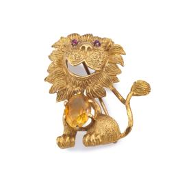 Lote 2115: Broche en forma de león con un cuarzo citrino talla oval y dos rubíes, en m ontura de oro amarillo de 18K.