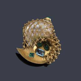 Lote 2211
Broche con diseño de 'Cuerno de la abundancia' con caracola cubierta por rejilla en oro amarillo, con aguamarina y esmeraldas.