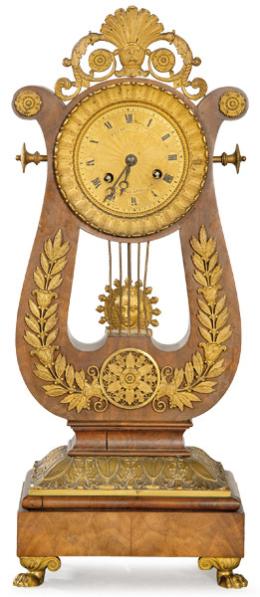 Lote 1251
Reloj de sobremesa imperio en madera de caoba y bronce dorado. Sobre un basamento cuadrado, se sitúa la caja del reloj en forma de lira que aloja la esfera del reloj. Francia, primer tercio S. XIX