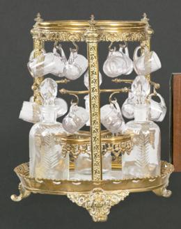 Lote 1466
Soporte para licoreras y tazas de bronce dorado con tres licoreras de cristal tallado con 12 tazas a juego ff. S. XIX pp. S. XX.