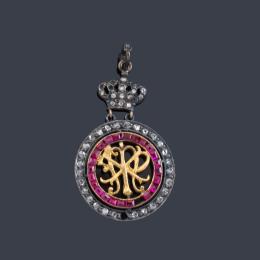 Lote 2017
Colgante con corona real, dos iniciales y doble orla de rubíes calibrados y diamantes talla rosa.