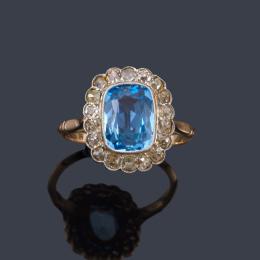 Lote 2074
Anillo años '20 con topacio azul talla oval con orla de diamantes talla antigua de aprox. 0,68 ct en total.
