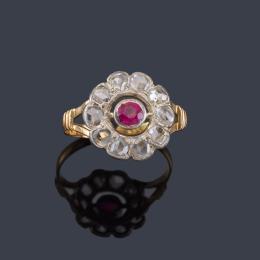 Lote 2092
Anillo con diseño de rosetón con rubí central sintético y orla de diamantes talla rosa. Años '30.