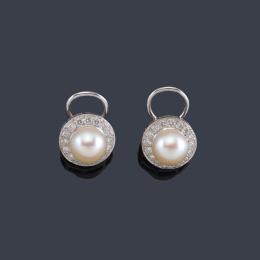 Lote 2412
Pendientes cortos con pareja de perlas y orla de brillantes en montura de oro blanco de 18K.