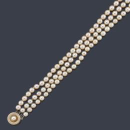 Lote 2463
Collar con tres hilos de perlas en diferentes longitudes con broche circular de oro amarillo y blanco de 18K.